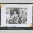 Man playing guitar to two men and a woman (ddr-densho-434-229)