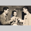 Two men and a young woman toasting with drinks (ddr-njpa-4-25)