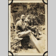 Two men sitting on bench smoking (ddr-densho-423-513)