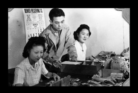 Sanaye Yoshimoto, Kataro Wunno, and Chizuru Kawashiri in the cashier office, Amache Co-op (ddr-csujad-55-1549)