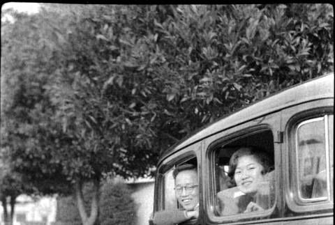 Man and woman inside car, man sitting on running board (ddr-densho-426-2018)