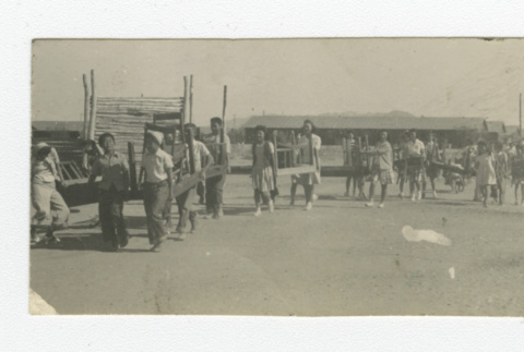 Nisei men, women, and children carrying furniture (ddr-csujad-44-51)