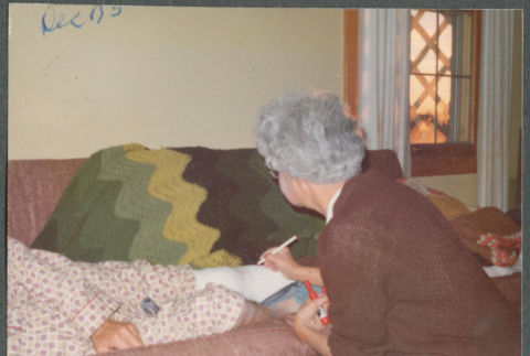 Agnes Sakura signing someone's leg cast (ddr-densho-523-644)