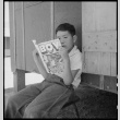 Young Japanese American reading comics (ddr-densho-151-472)