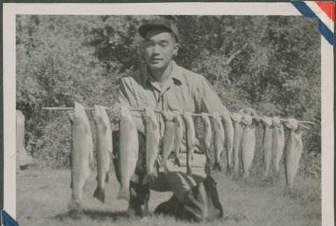 Masao Sakagami holding fish (ddr-densho-201-950)