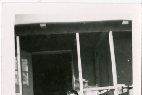 Girl standing in doorway of barracks (ddr-densho-329-1321)