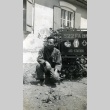 Soldier kneeling next to a 522 FABN Aid Station sign (ddr-densho-22-432)