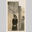 Tomoye (Nozawa) Takakashi standing by stone pillar (ddr-densho-423-469)