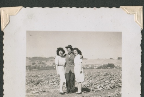 Man and two women in crop field (ddr-densho-321-184)