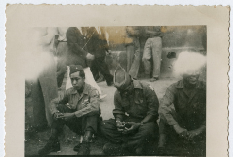 Soldiers sitting along street curb (ddr-densho-368-104)