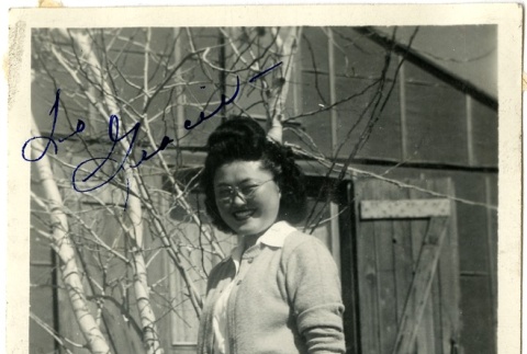 Signed photograph of a woman standing in front of barracks (ddr-manz-6-87)