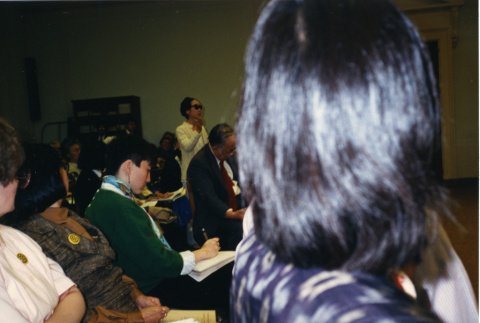 NCJAR press conference: Alice Basoms (white blouse), Chizu Omori (suit) Penny Willgerodt (green sweater), and Michi Weglyn (standing). (ddr-csujad-29-286)