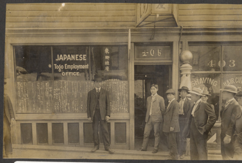 Men stand outside the Japanese Togo Employment Agency (ddr-sbbt-1-15)