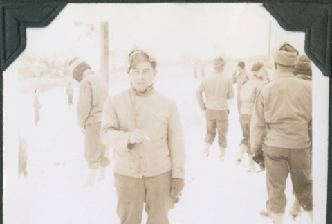Man standing in snow smoking a cigarette (ddr-ajah-2-454)