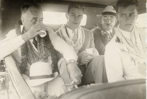 Franklin D. Roosevelt and others sitting in a car wearing leis (ddr-njpa-1-1639)