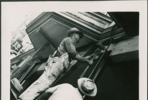 Two men working on support post, one hammering (ddr-densho-426-2262)