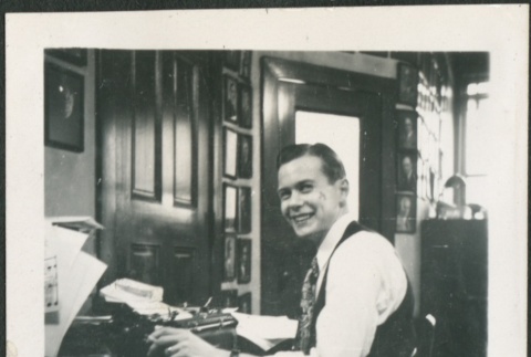Dave Richmond seated at his desk (ddr-densho-298-226)