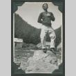 Man standing on rock with hand over heart (ddr-densho-540-97)