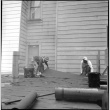 Two men laying tar paper on roof (ddr-densho-426-2159)