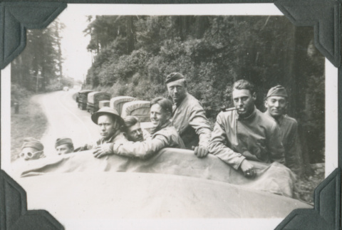 Men in back of truck with line of trucks behind (ddr-ajah-2-211)