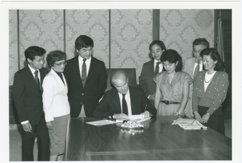 Signing of resolution seeking redress for Nisei who lost their jobs with the Seattle School District (ddr-densho-10-168)