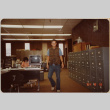 Man walking past file cabinets in office (ddr-densho-426-1352)