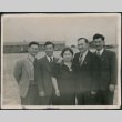 Four men and a woman with barracks in background (ddr-densho-523-140)