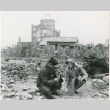 Ted Akimoto and a woman look at pieces of rubble from blast (ddr-densho-299-148)