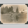 Two children running across field holding hands (ddr-densho-483-545)