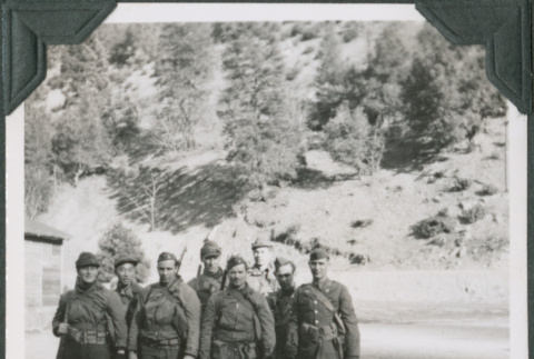 Eight men in uniform standing alongside road (ddr-ajah-2-317)
