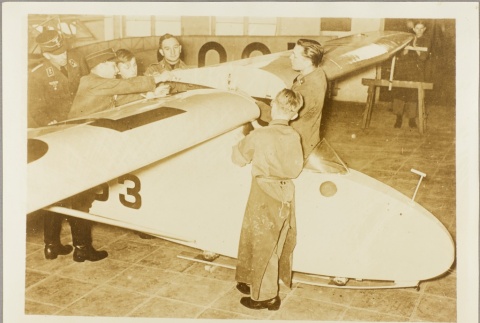 German boys assembling a glider while a Nazi officer supervises (ddr-njpa-13-842)