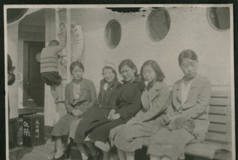 Women pose on bench aboard ship (ddr-densho-359-822)