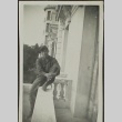 Japanese American soldier sitting on a balcony railing (ddr-densho-201-385)