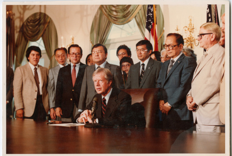 Men standing behind President Jimmy Carter in White House, signing of Commission of Wartime Relocation and Internment of Citizens Act into law (ddr-densho-393-4)