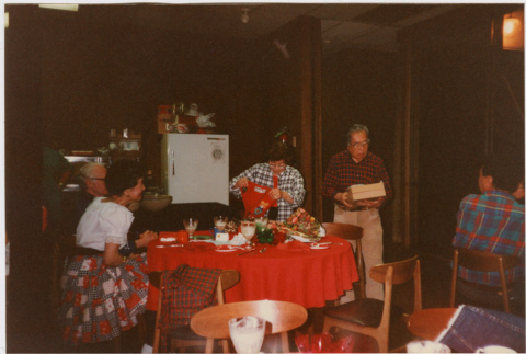 Tomoye and Henri Takahashi standing by table with gifts (ddr-densho-426-1294)