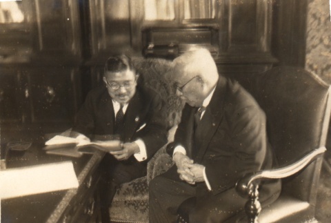 Two men reading a document (ddr-njpa-4-77)