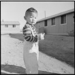 Child standing between barracks (ddr-densho-37-777)