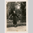 Tomoye Nozawa standing by metal fence (ddr-densho-423-482)