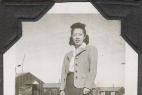 Woman standing with barracks in background (ddr-densho-466-198)