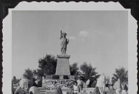 Three children posing under a replica Statue of Liberty (ddr-densho-300-592)