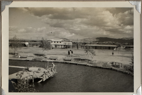 Three girls walking by canal with building in background (ddr-densho-587-13)