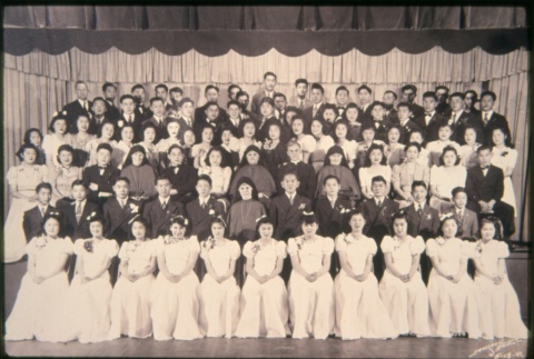 Young men in sutis and young women in white dresses, nuns and priests seated (ddr-densho-330-29)