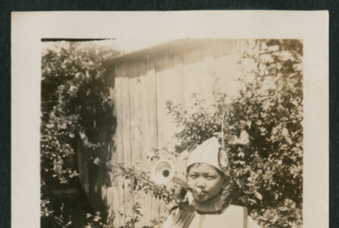 Boy in costume playing trumpet (front) (ddr-densho-378-451)