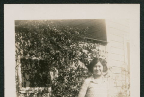 girl outside shed next to tall plants (ddr-densho-378-423)