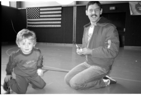 Man with child on gym floor (ddr-densho-1007-1259)