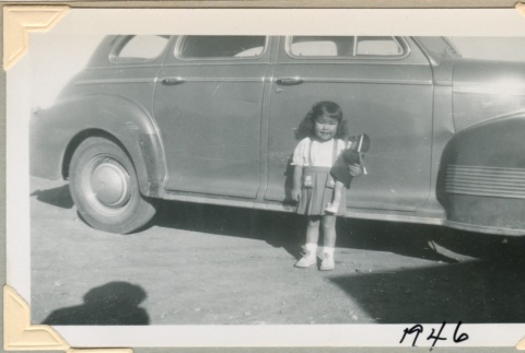 A girl standing in front of a car (ddr-densho-300-142)