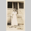 Ruth Morita standing outside a house in a long white dress (ddr-densho-409-34)