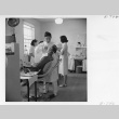 Dentist, Dr. T. Nakamura, working on a patient's teeth (ddr-fom-1-855)