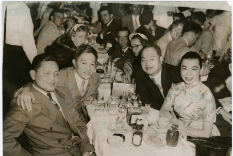 Mary Mon Toy with a large group sitting at tables (ddr-densho-367-159)