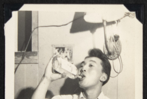 Man drinking from a bottle (ddr-densho-542-759)